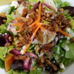 Colorful salad with mixed greens, carrots, and pecans—perfect for outdoor dining at Augie’s.