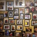 A wall at Augie’s displays many framed family photos in a captivating collage pattern.
