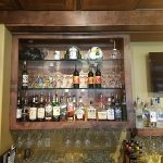 Wooden bar shelf with assorted liquor bottles, perfect for steakhouses and restaurants in Prescott.