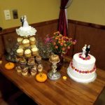 Wedding dessert table with cupcakes, floral cake, and pumpkins—perfect for Banquet Rooms Prescott.