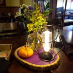 Small lamp, pumpkin, and flowers adorn a wooden tray at one of the top restaurants in Prescott.