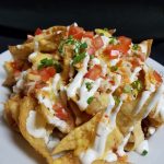 Plate of nachos at Augie’s, a standout among restaurants in Prescott, topped with fresh ingredients.