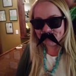 Woman with long blonde hair wears sunglasses and a fake mustache at Augie’s in Prescott.