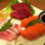 A plate of assorted sashimi, perfect for outdoor dining in Prescott, served with soy sauce.