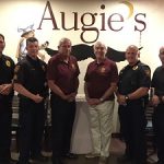 Six men in uniform stand inside Augie’s, a popular restaurant and cocktail lounge in Prescott.
