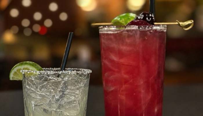 Two cocktails with straws and lime sit ready at our cocktail lounge bar in Prescott.