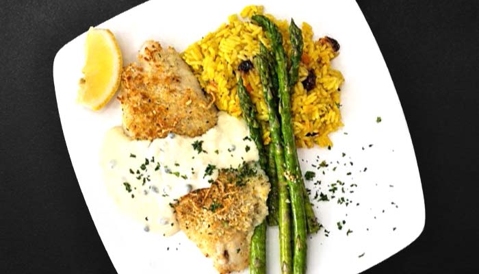 Breaded fish with sauce, yellow rice, asparagus, and lemon at Augie’s in Prescott.