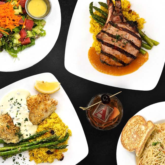 Steakhouse Prescott: Four plates of grilled meats, fish, salad, pasta, and a cocktail on a black table.
